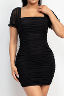 Vestido negro ajustado con mangas de tul